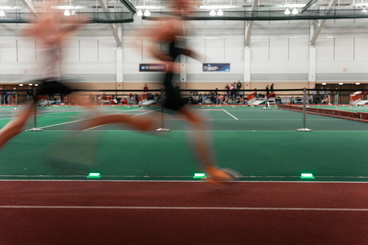 Runners moving past Stridelane pacing lights during an indoor race