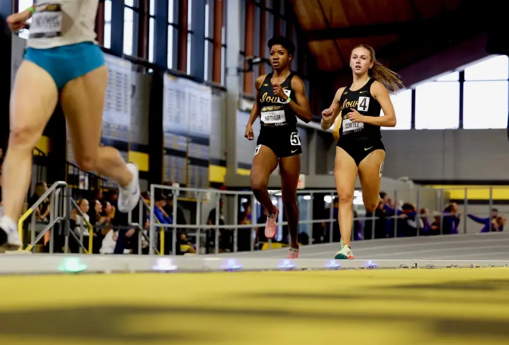 Athletes racing indoors with Stridelane lights placed along the curve