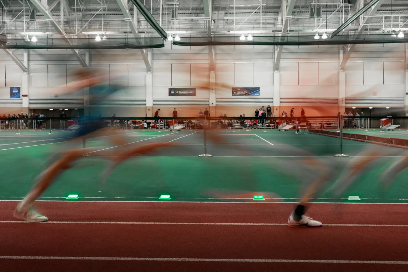 Indoor runners moving beside green and orange Stridelane pacing lights