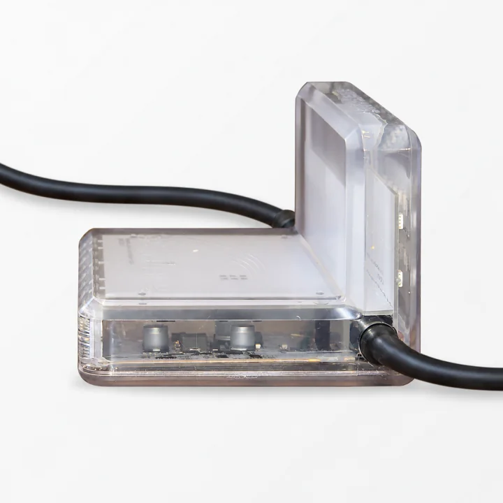 Side view of a clear Stridelane pacing-light module showing its low profile and connected cables